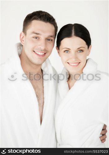 healthcare and beauty concept - picture of couple in spa salon in white bathrobes
