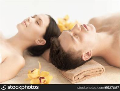 healthcare and beauty concept - picture of couple in spa salon lying on the massage desks