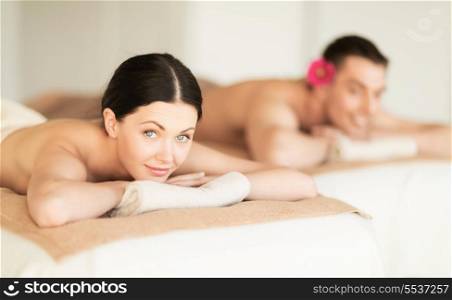 healthcare and beauty concept - picture of couple in spa salon lying on the massage desks