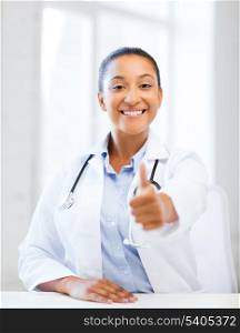 healthcare and medical concept - african doctor with stethoscope showing thumbs up