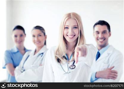 healthcare and medical concept - attractive female doctor in front of medical group. female doctor in front of medical group