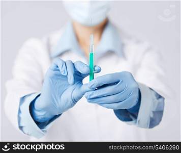 healthcare and medical concept - close up of female doctor holding syringe with injection