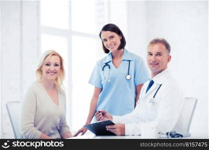 healthcare and medical concept - doctor and nurse with patient in hospital. doctor and nurse with patient in hospital