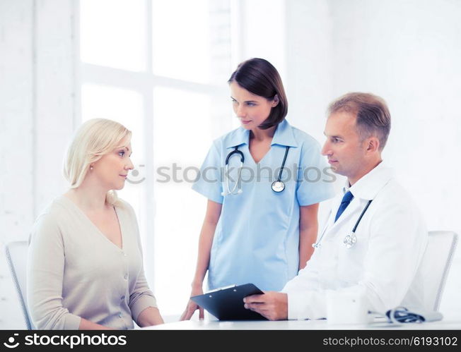 healthcare and medical concept - doctor and nurse with patient in hospital. doctor and nurse with patient in hospital