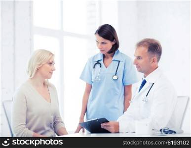 healthcare and medical concept - doctor and nurse with patient in hospital. doctor and nurse with patient in hospital
