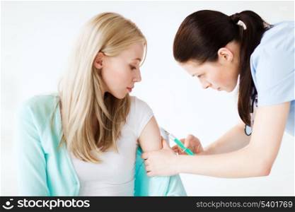 healthcare and medical concept - doctor doing vaccine to patient