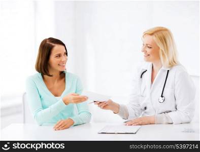 healthcare and medical concept - doctor giving prescription to patient in hospital