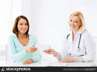 healthcare and medical concept - doctor giving prescription to patient in hospital