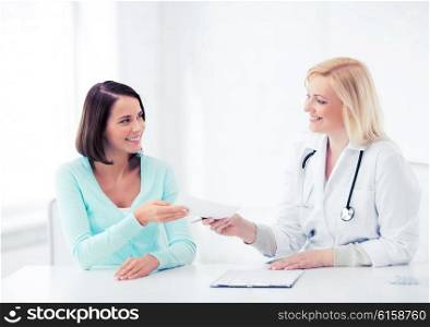 healthcare and medical concept - doctor giving prescription to patient in hospital. doctor giving prescription to patient in hospital