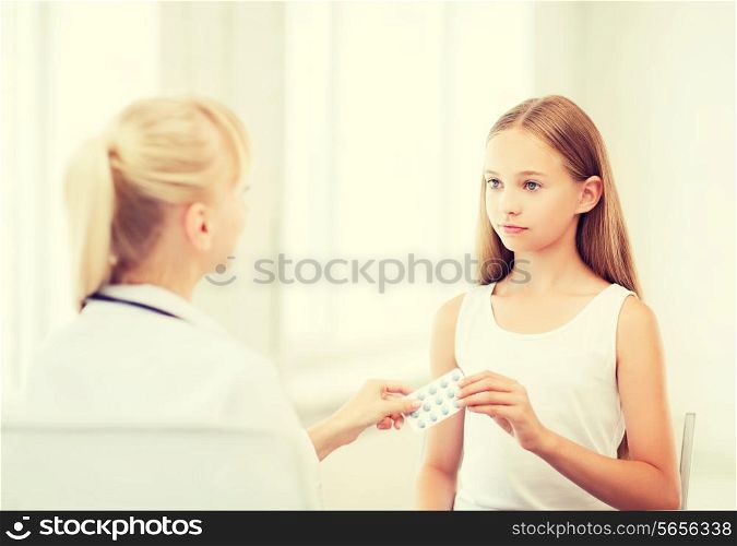 healthcare and medical concept - doctor giving tablets to child in hospital