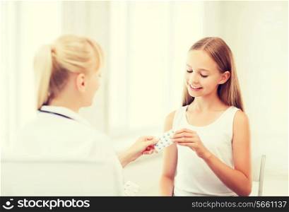 healthcare and medical concept - doctor giving tablets to child in hospital
