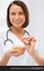 healthcare and medical concept - doctor holding bowl of capsules