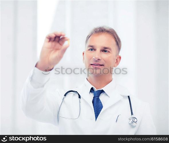 healthcare and medical concept - doctor holding omega 3 capsule. doctor with tablet in hospital