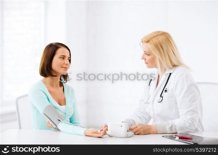 healthcare and medical concept - doctor measuring patient&#39;s blood pressure