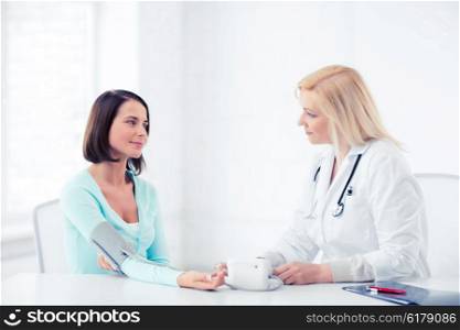 healthcare and medical concept - doctor measuring patient&amp;#39;s blood pressure