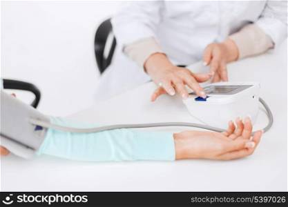 healthcare and medical concept - doctor or nurse with patient measuring blood pressure