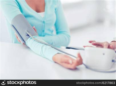 healthcare and medical concept - doctor or nurse with patient measuring blood pressure. doctor and patient in hospital