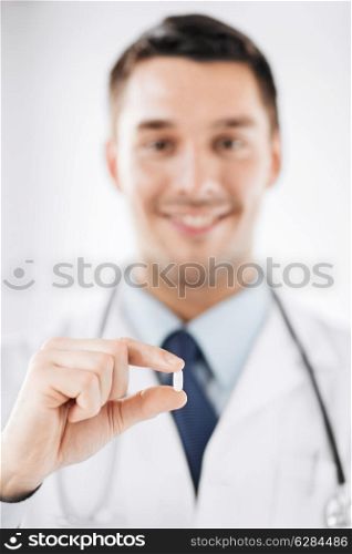 healthcare and medical concept - doctor with pill in hospital