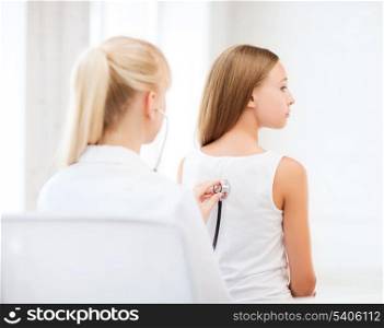 healthcare and medical concept - doctor with stethoscope listening to child back in hospital