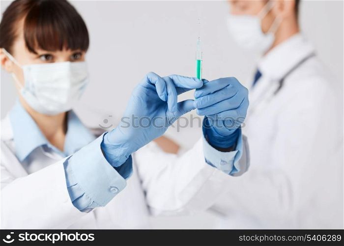 healthcare and medical concept - doctors with syringe