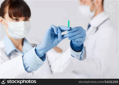 healthcare and medical concept - doctors with syringe
