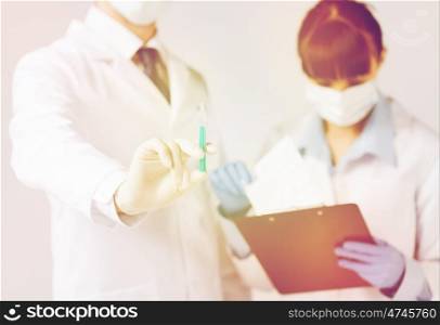 healthcare and medical concept - doctors with syringe. doctors with syringe