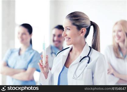 healthcare and medical concept - female doctor holding syringe with injection. female doctor holding syringe with injection