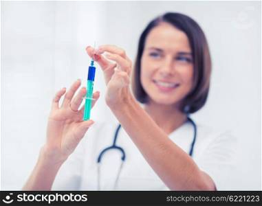 healthcare and medical concept - female doctor holding syringe with injection. female doctor holding syringe with injection