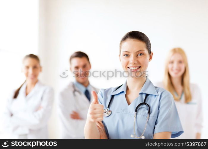 healthcare and medical concept - female doctor with group of medics showing thumbs up