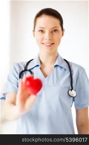 healthcare and medical concept - female doctor with heart