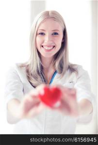 healthcare and medical concept - female doctor with heart. female doctor with heart