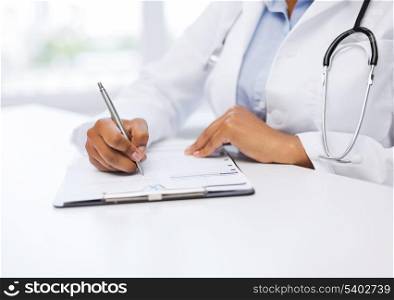 healthcare and medical concept - female doctor writing prescription