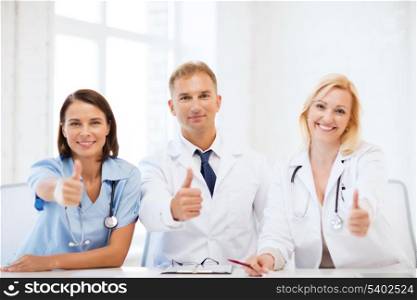 healthcare and medical concept - group of doctors on a meeting showing thumbs up