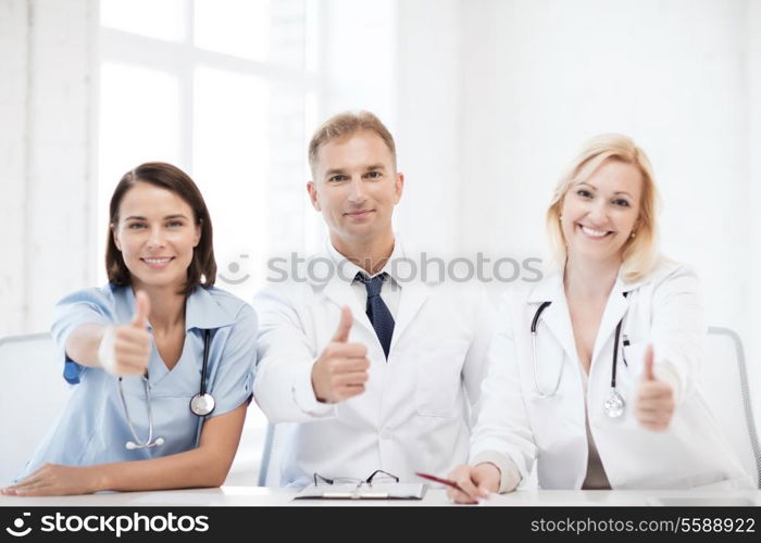 healthcare and medical concept - group of doctors on a meeting showing thumbs up