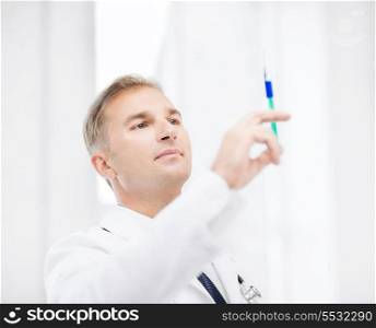 healthcare and medical concept - male doctor holding syringe with injection