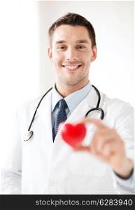 healthcare and medical concept - male doctor with heart
