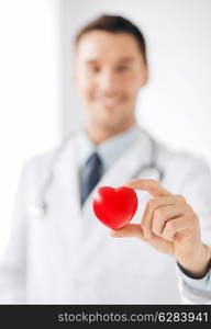 healthcare and medical concept - male doctor with heart