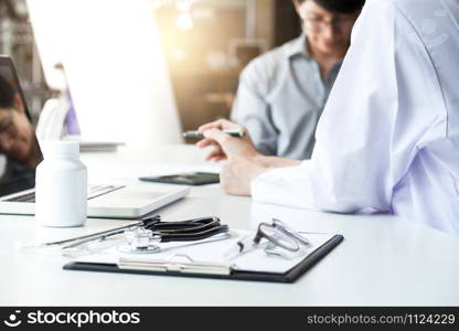 Healthcare and Medical concept, patient listening intently to a female doctor explaining patient symptoms or asking a question as they discuss paperwork together in a consultation.