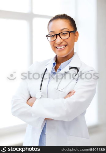 healthcare and medical concept - smiling african female doctor in hospital