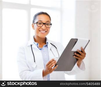 healthcare and medical concept - smiling african female doctor with prescription in hospital