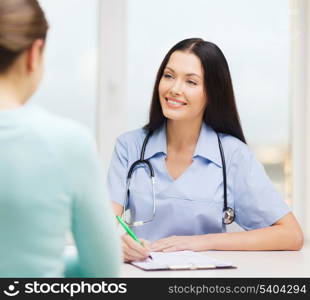 healthcare and medical concept - smiling female doctor or nurse with patient writing prescription