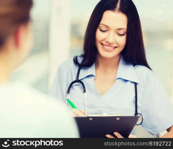 healthcare and medical concept - smiling female doctor or nurse with patient writing prescription. smiling doctor or nurse with patient