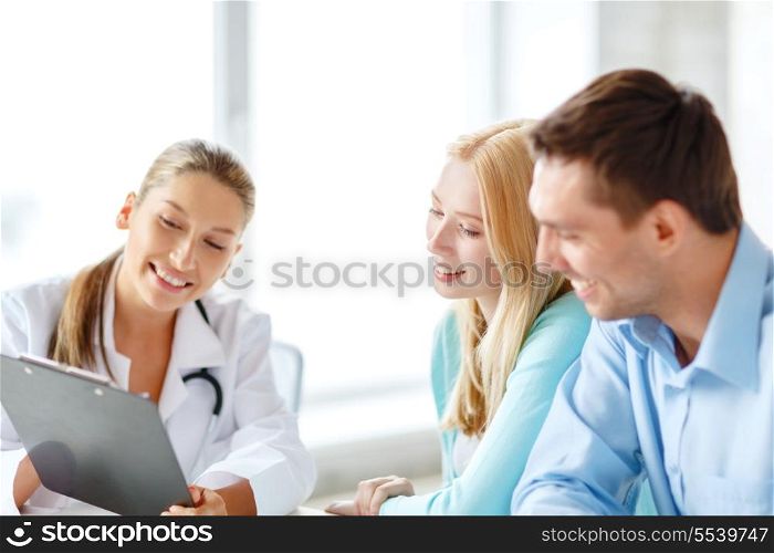 healthcare and medical concept - smiling female doctor with clipboard and patients in hospital