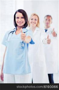 healthcare and medical concept - team of doctors showing thumbs up. team of doctors showing thumbs up