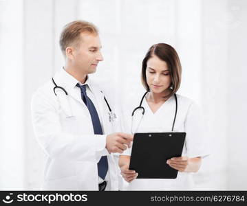 healthcare and medical concept - two doctors discussing diagnosis