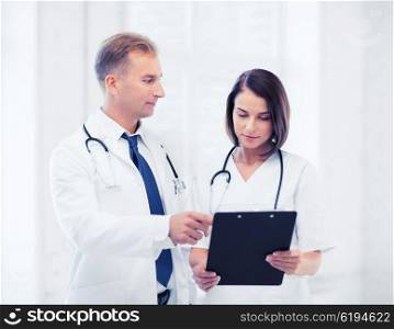 healthcare and medical concept - two doctors discussing diagnosis. two doctors writing prescription