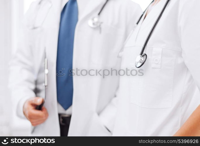 healthcare and medical concept - two doctors with stethoscopes