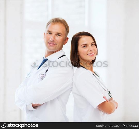 healthcare and medical concept - two doctors with stethoscopes