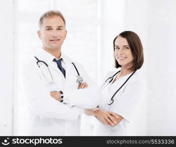 healthcare and medical concept - two doctors with stethoscopes