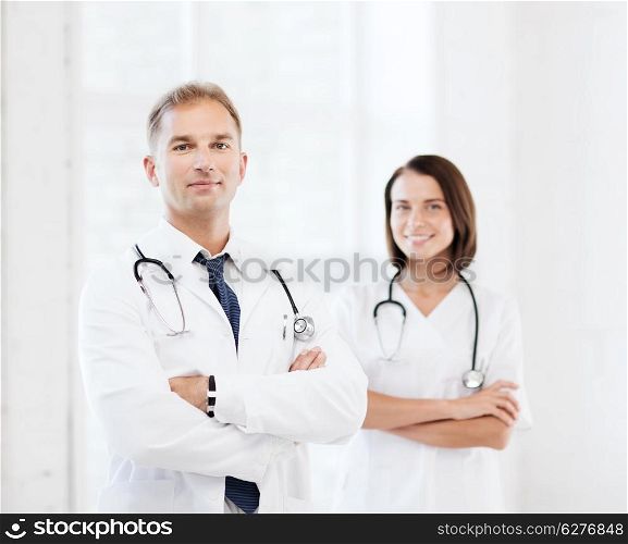 healthcare and medical concept - two doctors with stethoscopes